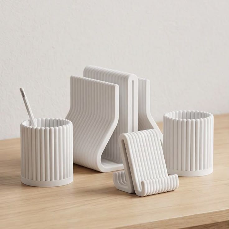 White ribbed pen cups and phone stands on a wooden shelf